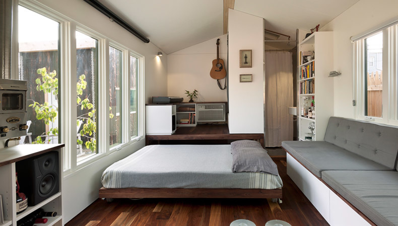 Bed pulls out from space underneath a raised floor platform